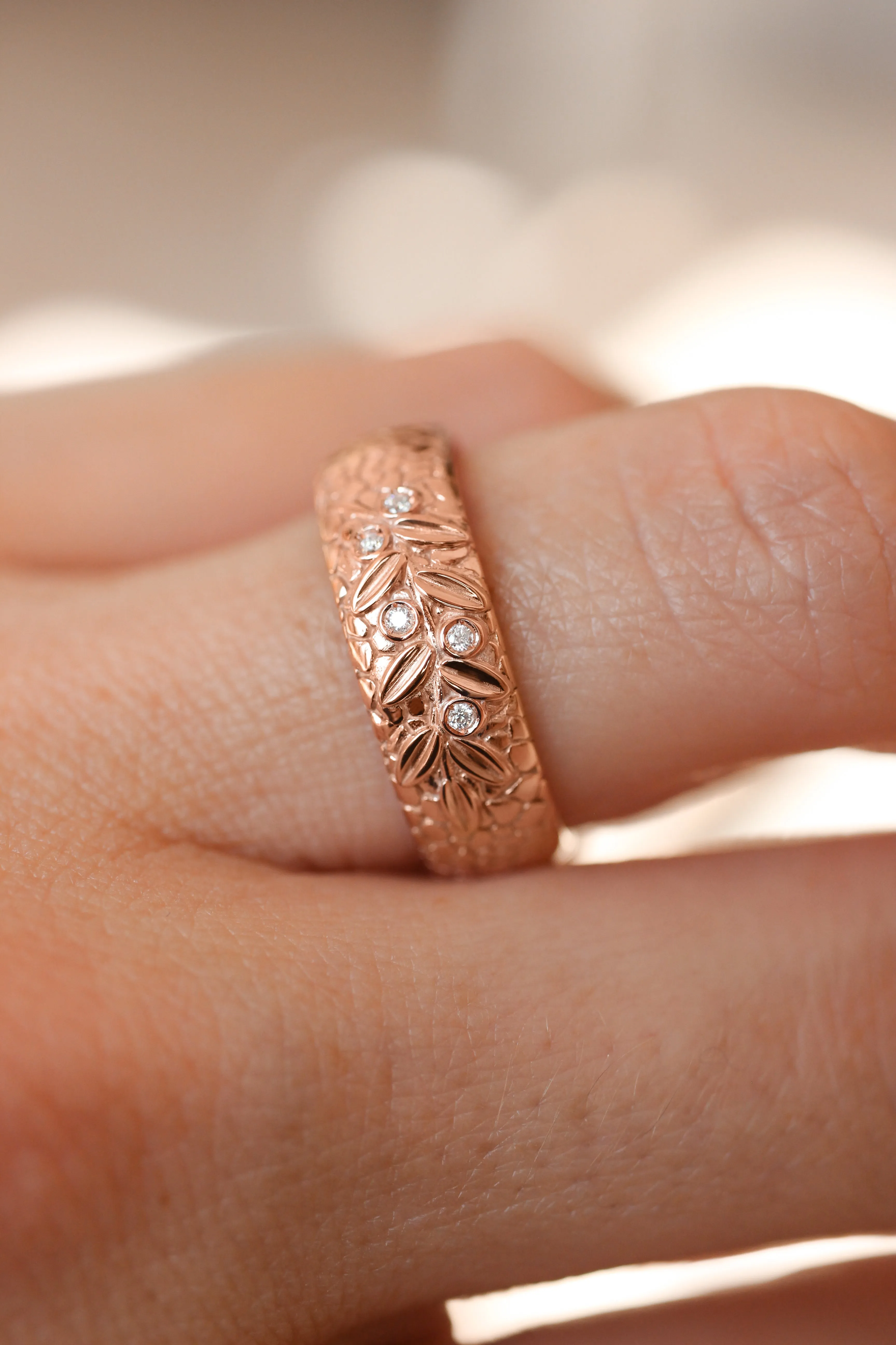 Textured wedding band with olive branch and diamonds